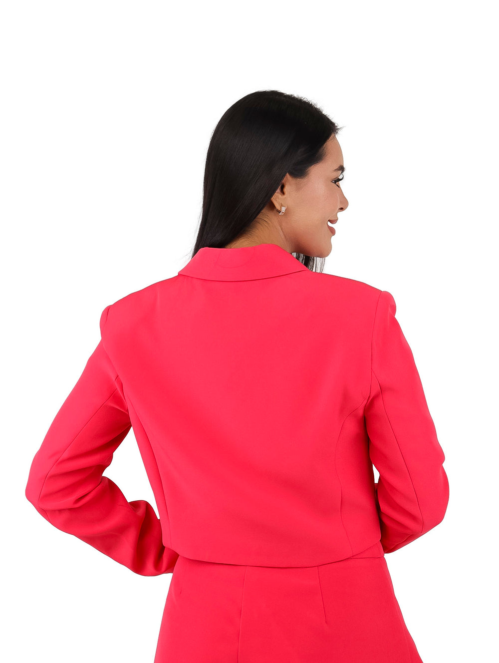 Mujer vistiendo un saco corto y falda en color coral.