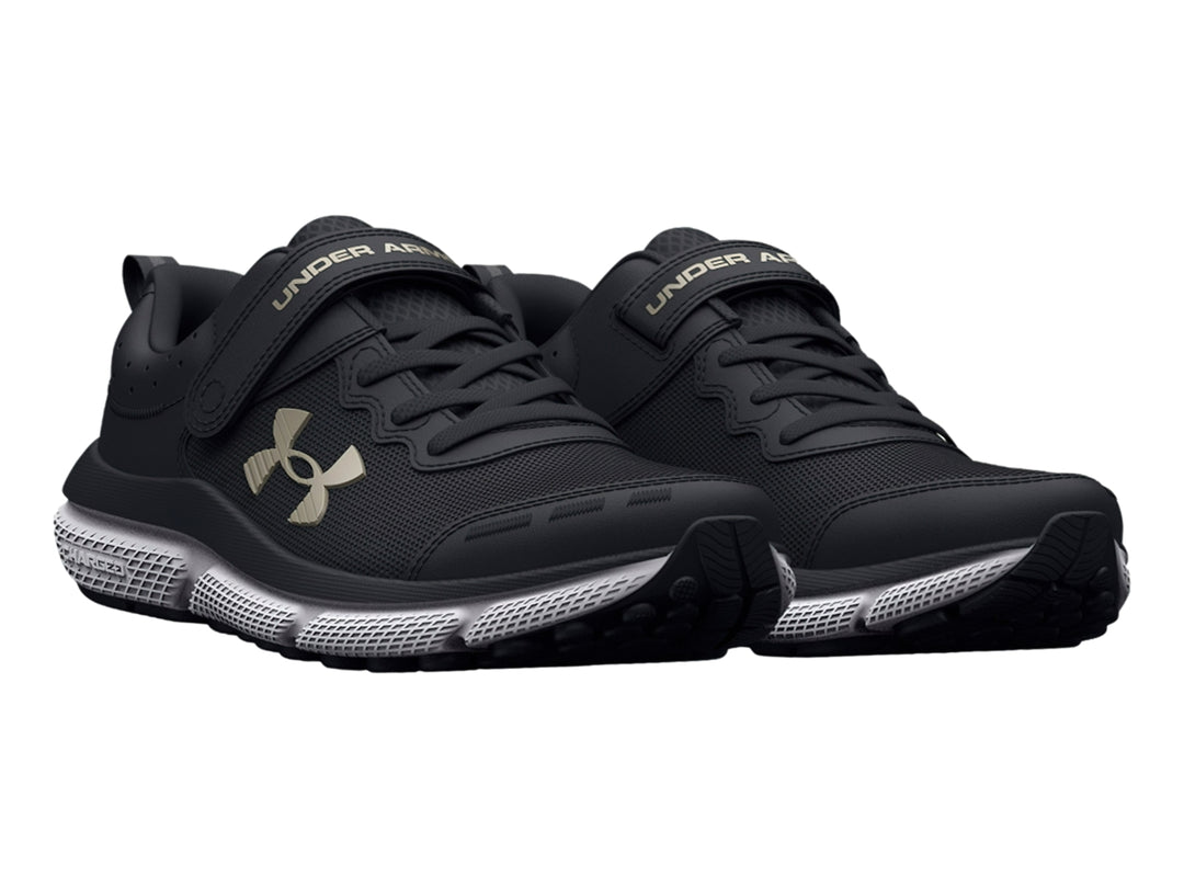 Tenis deportivos Under Armour color negro con suela blanca y cierre de correa de velcro.