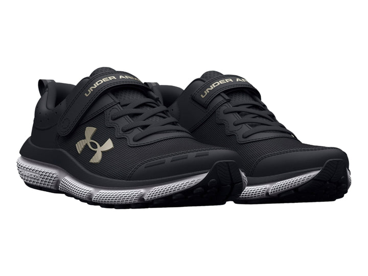 Tenis deportivos Under Armour color negro con suela blanca y cierre de correa de velcro.