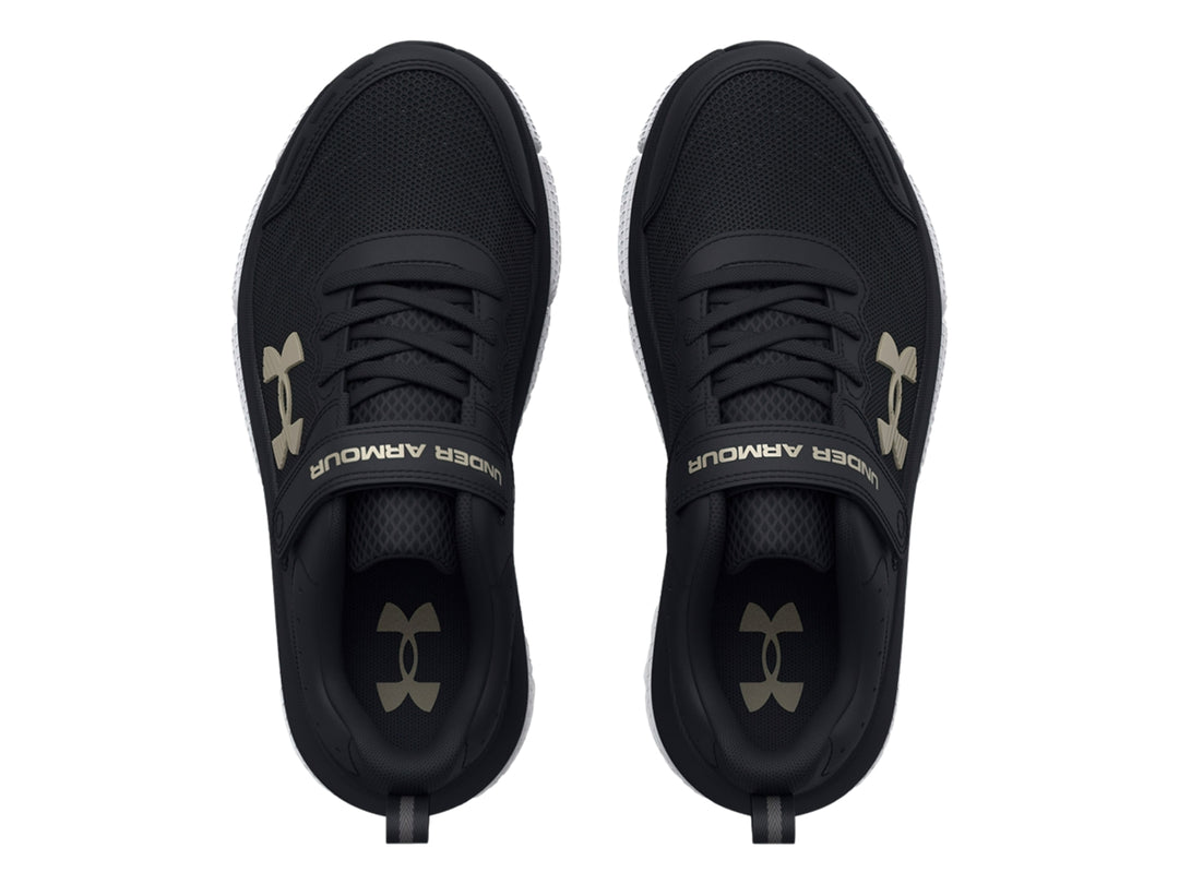Tenis deportivos Under Armour color negro con suela blanca y cierre de correa de velcro.