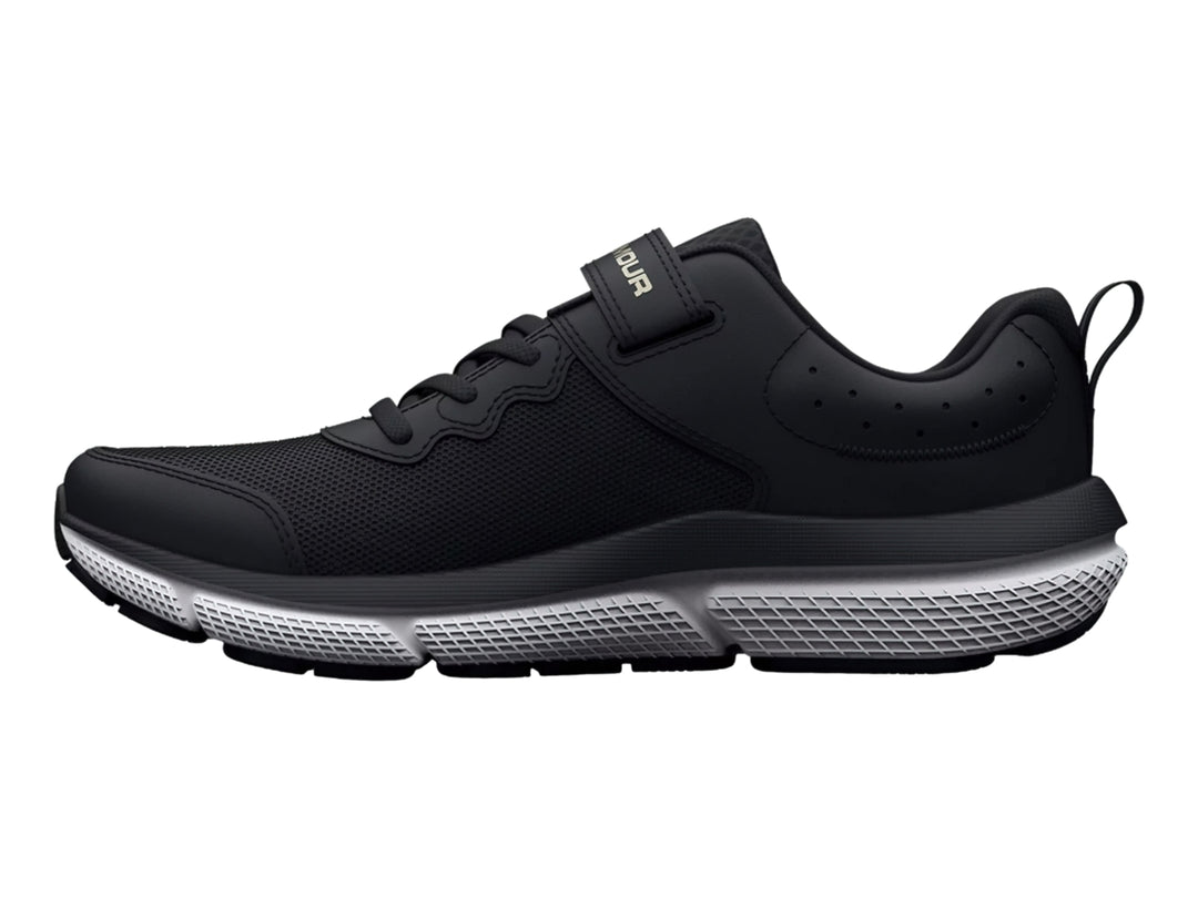 Tenis deportivos Under Armour color negro con suela blanca y cierre de correa de velcro.