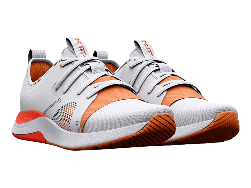 Tenis deportivos Under Armour color blanco con detalles y suela en color naranja.