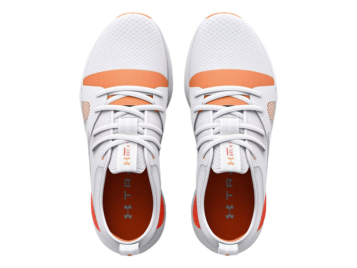 Tenis deportivos Under Armour color blanco con detalles y suela en color naranja.