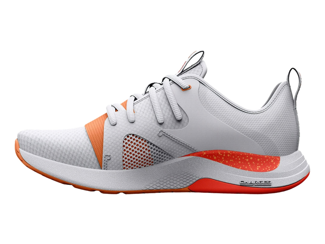 Tenis deportivos Under Armour color blanco con detalles y suela en color naranja.