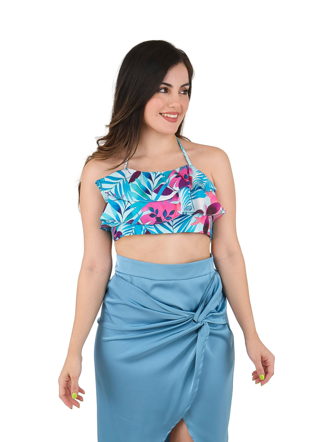 Mujer vistiendo un top corto azul aqua con estampado floral en tonos rosa y morado con detalles de volantes.