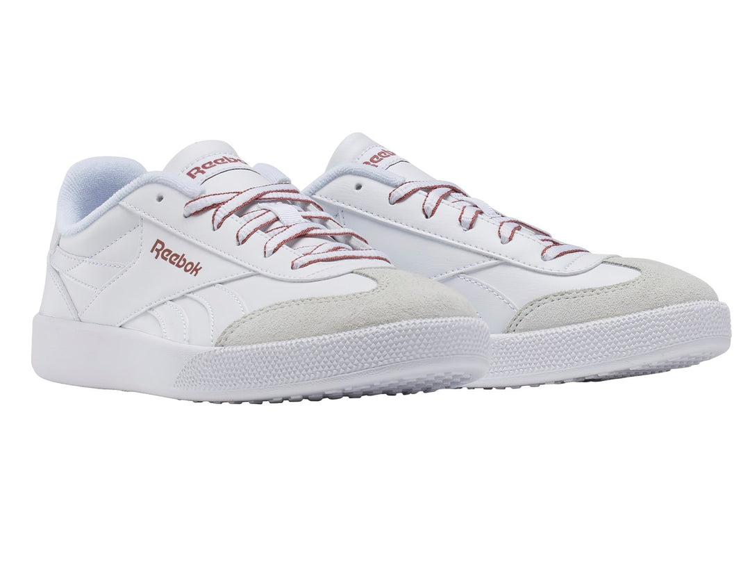 Tenis Reebok blancos con agujetas rosa y punta gris.