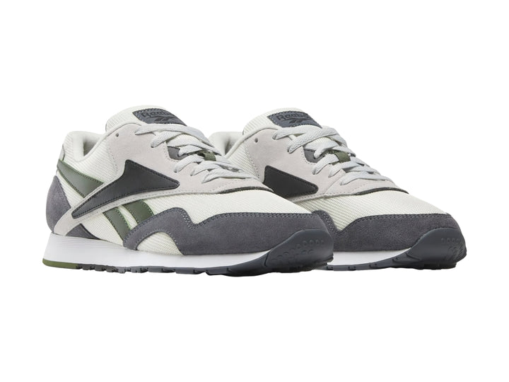 Tenis Reebok en colores gris, blanco y negro con detalles en verde oliva y suela blanca.