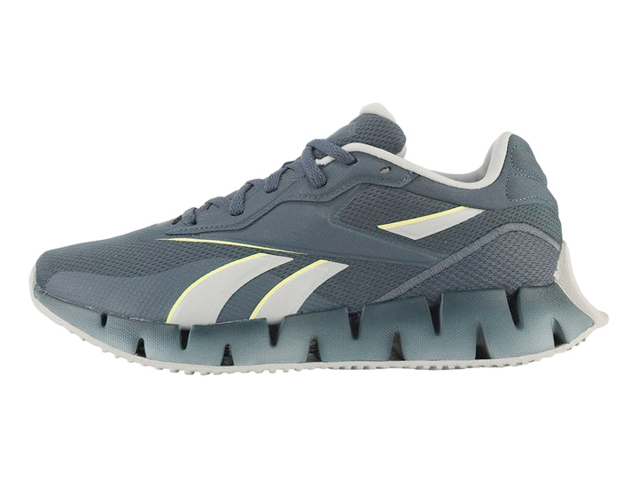 Tenis Reebok Zig Dynamica 4 en color azul con detalles en gris y amarillo, vista lateral.