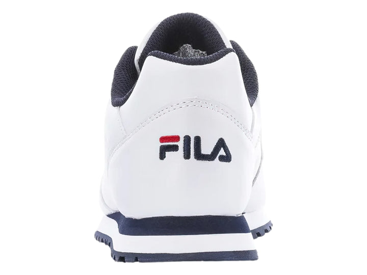 Tenis deportivos FILA de color blanco con suela azul marino y detalles en rojo.