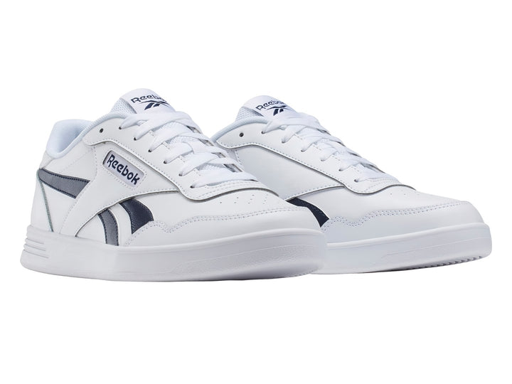 Tenis Reebok blancos con detalles en azul marino y suela blanca.