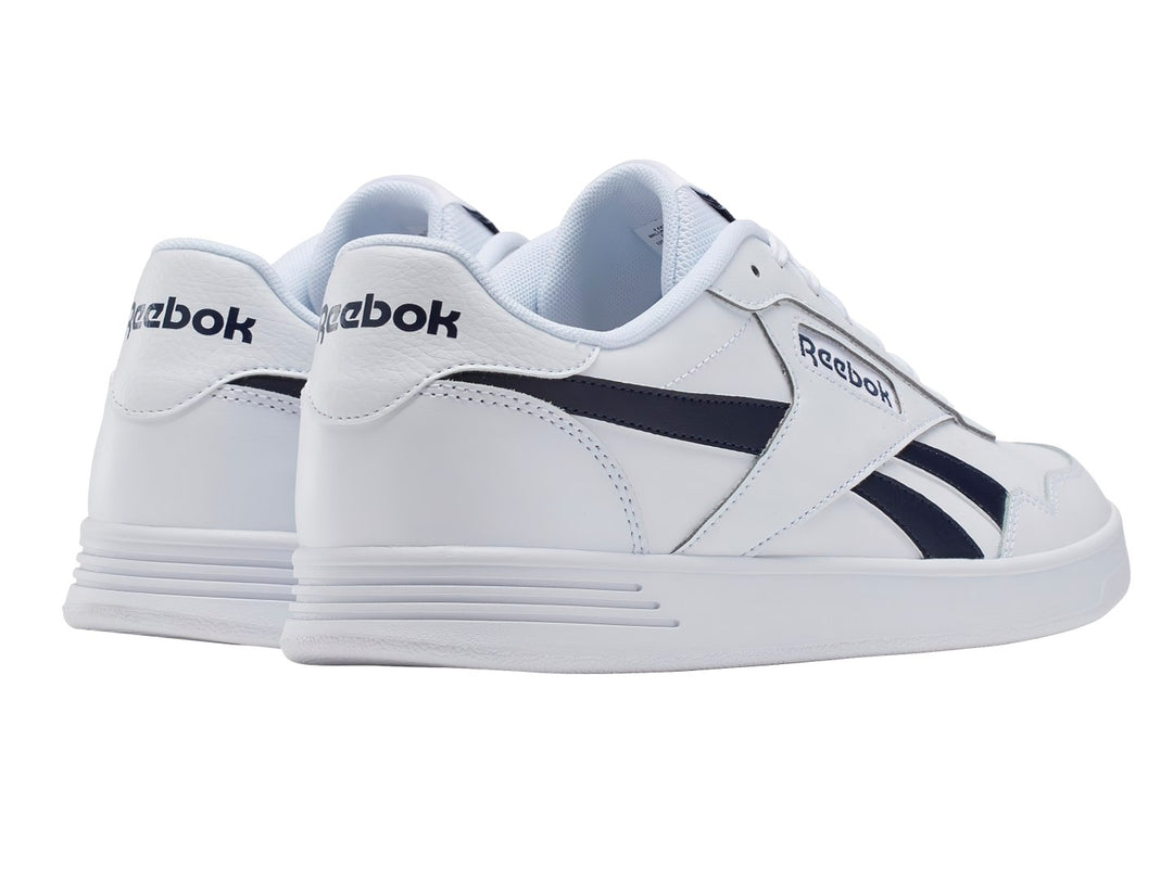 Tenis Reebok blancos con detalles en azul marino y suela blanca.