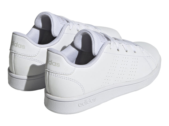 Tenis Adidas Advantage K color blanco con rayas laterales perforadas y suela plana blanca.