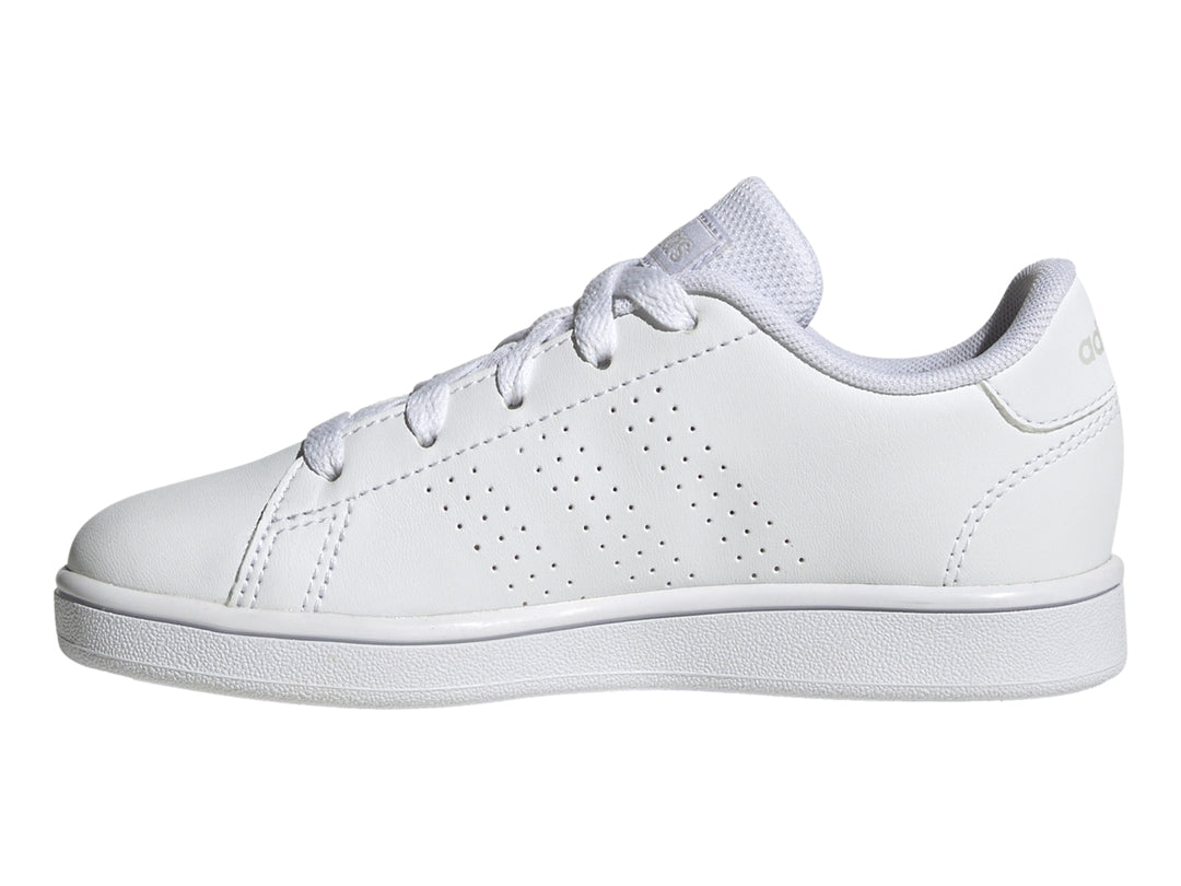 Tenis Adidas Advantage K color blanco con rayas laterales perforadas y suela plana blanca.
