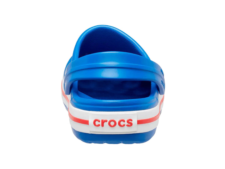 Zuecos Crocs para niños color azul con franjas blancas y rojas en la suela.