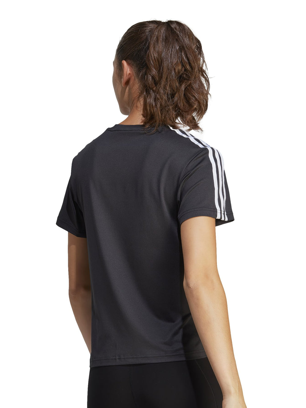 Mujer vistiendo playera deportiva Adidas color negro con tres franjas blancas en los hombros y logo frontal blanco.