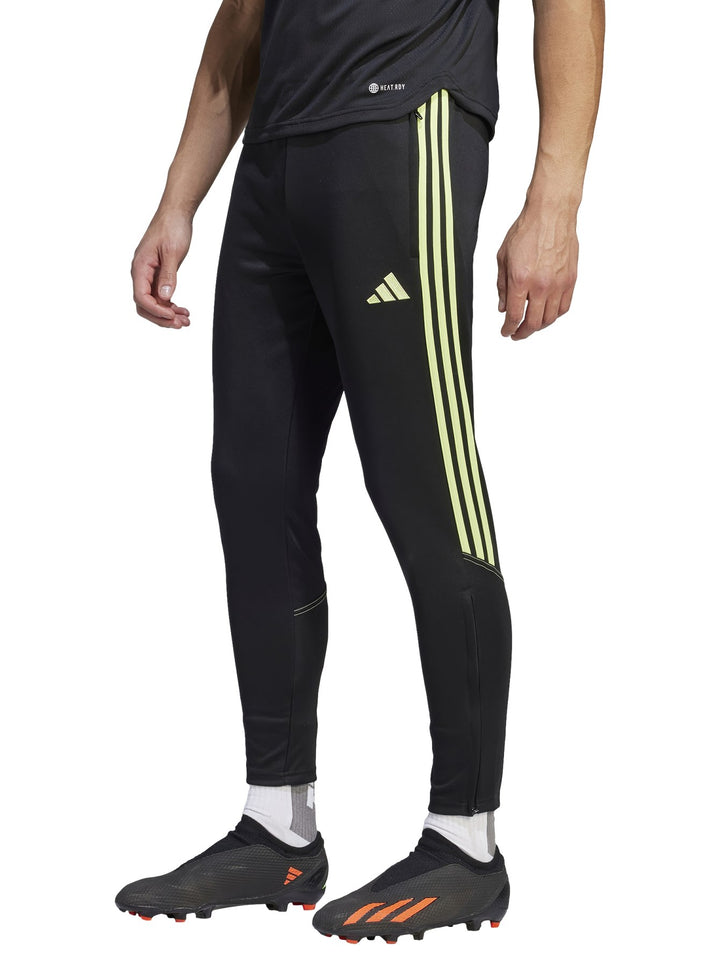 Pantalones deportivos Adidas negros con tres franjas laterales en color verde lima.