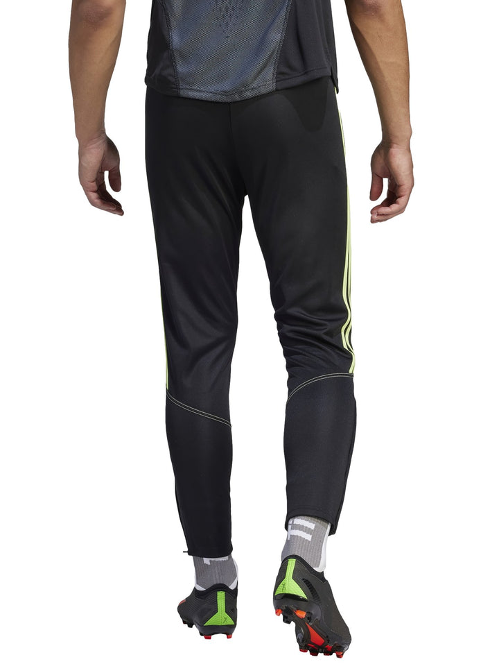 Pantalones deportivos Adidas negros con tres franjas laterales en color verde lima.