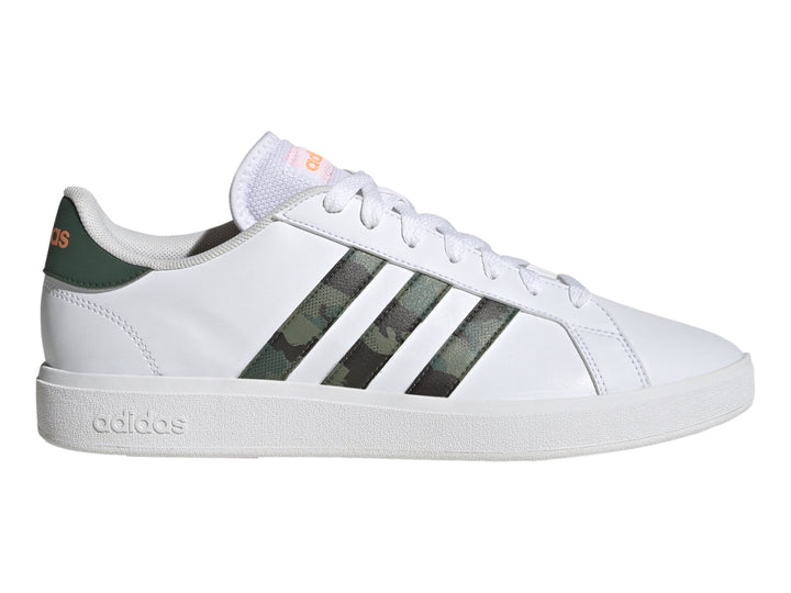 Tenis Adidas blancos con franjas laterales en patrón de camuflaje y detalles en naranja.