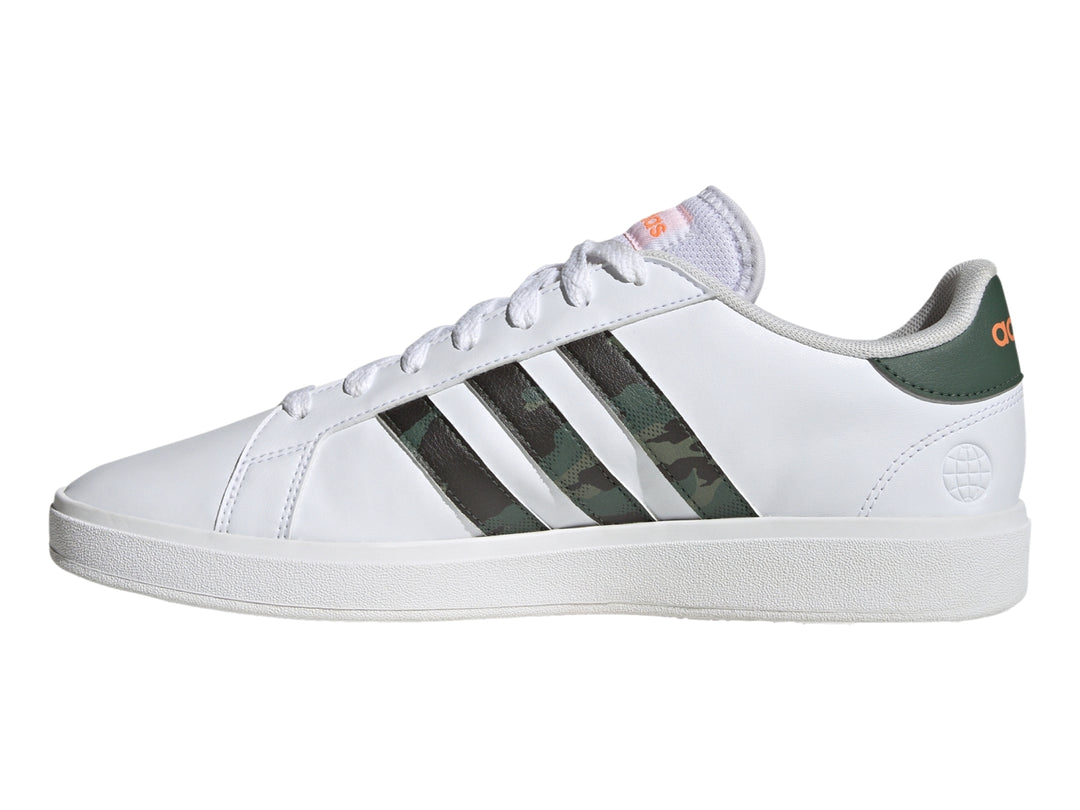 Tenis Adidas blancos con franjas laterales en patrón de camuflaje y detalles en naranja.