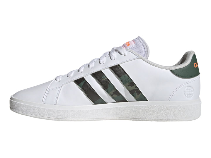 Tenis Adidas blancos con franjas laterales en patrón de camuflaje y detalles en naranja.