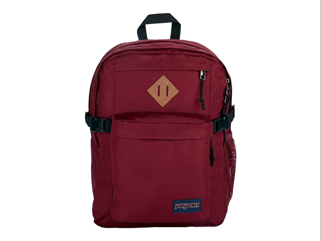 Mochila JanSport Main Campus en color rojo russet con detalles en negro y un parche café en el frente.