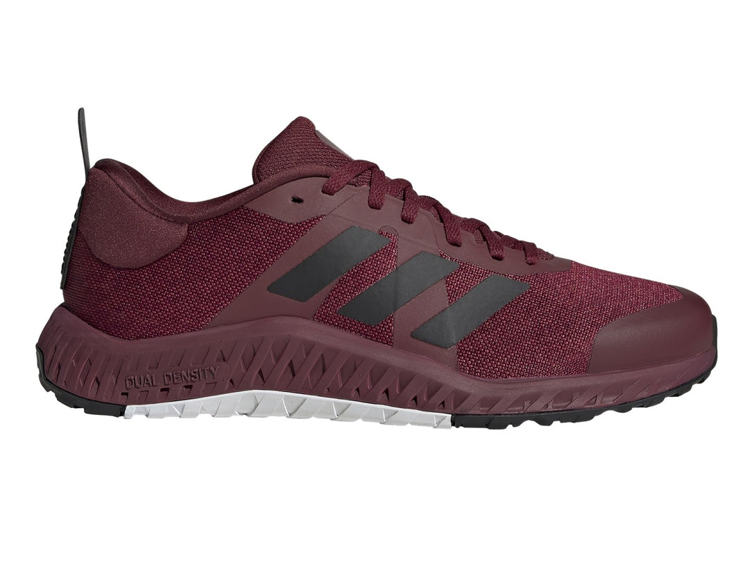 Tenis deportivos Adidas color rojo oscuro con franjas negras y suela blanca y negra.