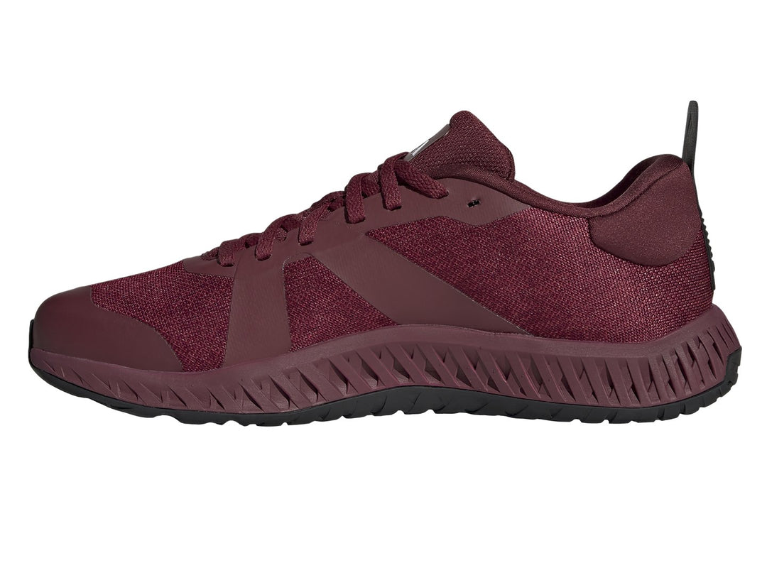 Tenis deportivos Adidas color rojo oscuro con franjas negras y suela blanca y negra.