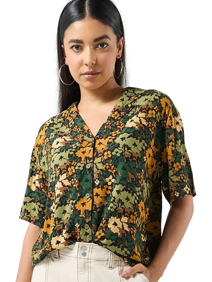 Camisa Vans de manga corta con estampado floral en tonos verde loden y amarillo, cuello en V y botones frontales.