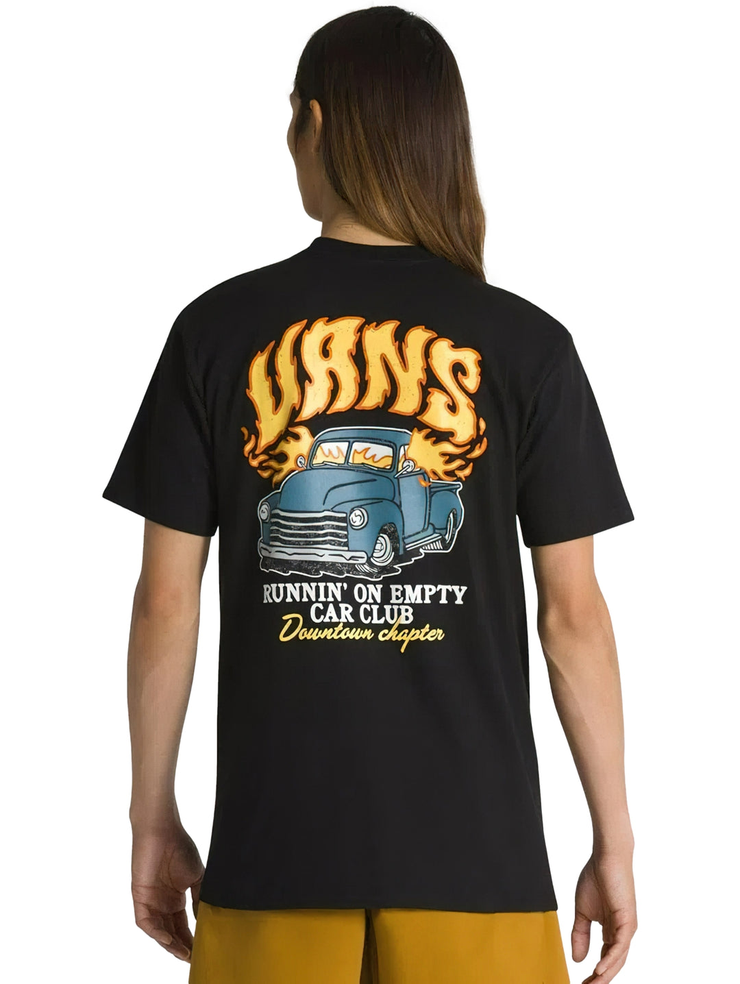 Hombre vistiendo una camiseta negra de manga corta VANS con un gráfico frontal de un auto y texto amarillo.