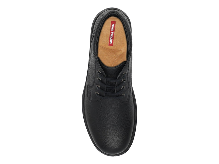 Botín de cuero negro marca Hush Puppies con cordones y suela negra.