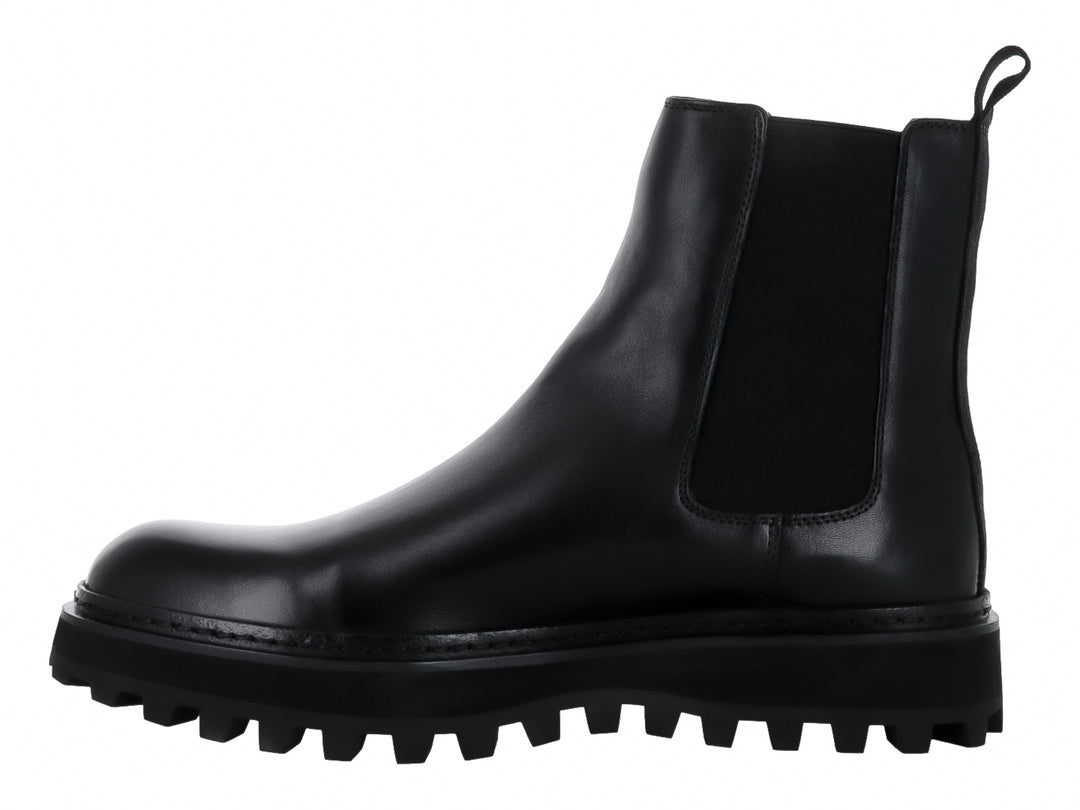 Bota Chelsea de cuero negro con suela track gruesa y dentada.