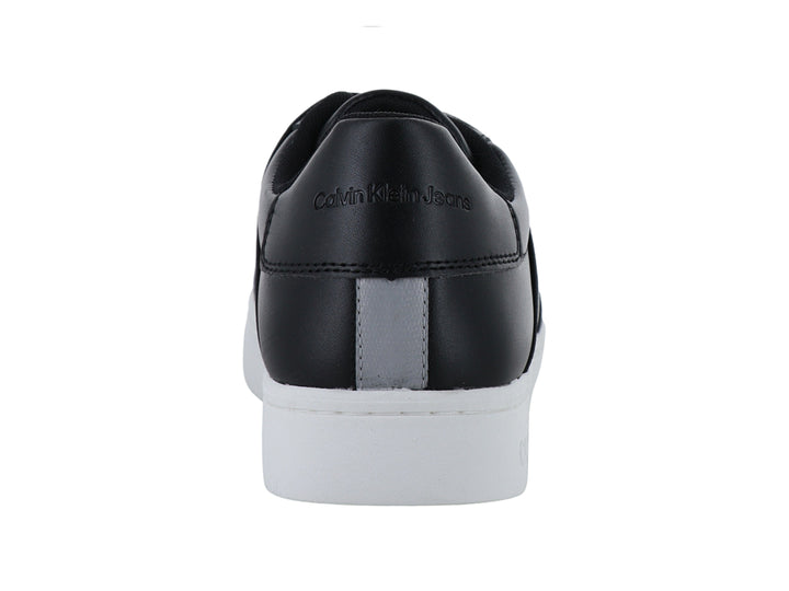 Tenis negros de Calvin Klein con suela blanca y correas elásticas frontales con logotipo.