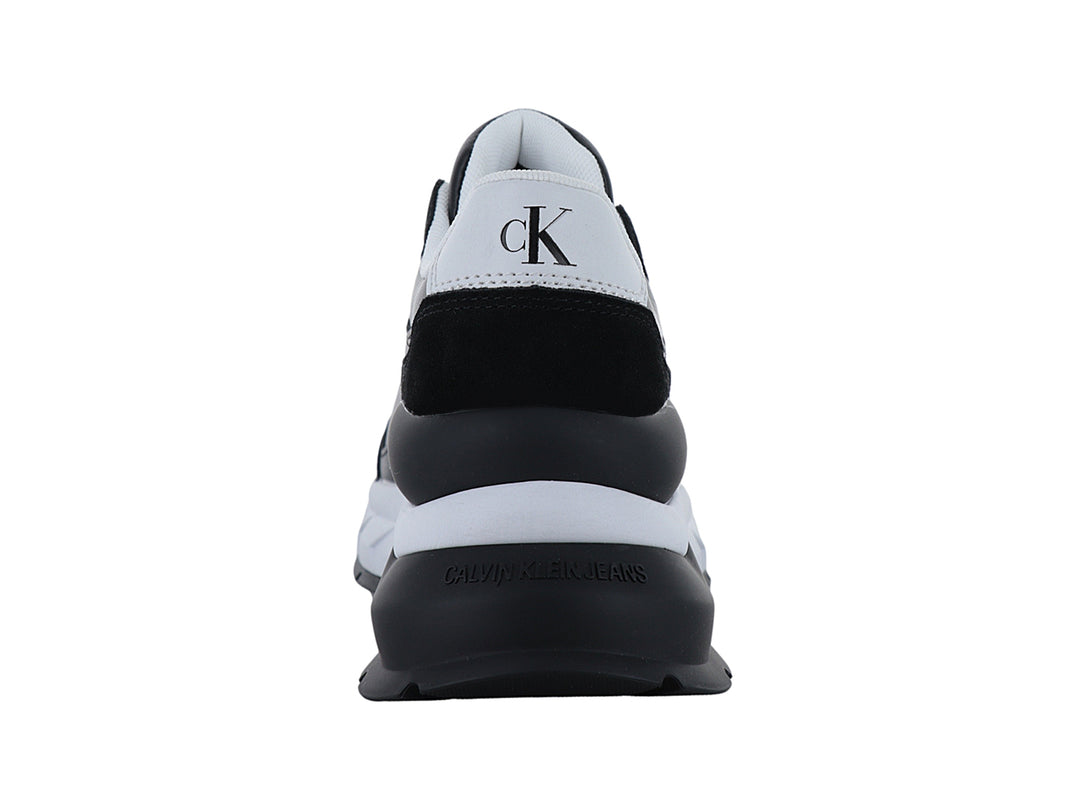 Tenis Calvin Klein color negro con suela blanca y logotipo CK blanco en el lateral.