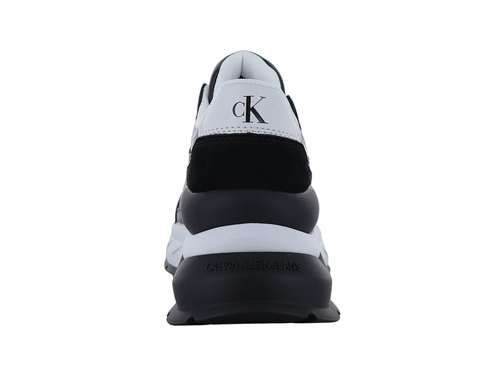 Tenis Calvin Klein color negro con suela blanca y logotipo CK blanco en el lateral.