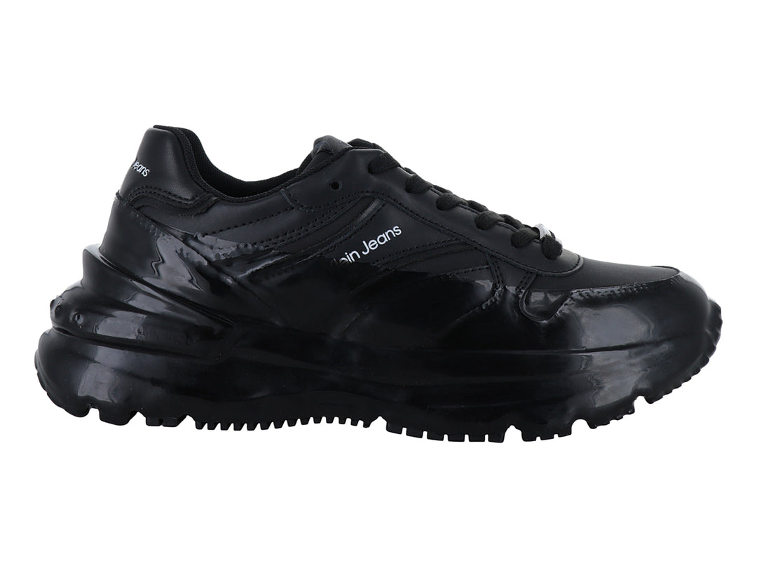 Tenis deportivos Calvin Klein en color negro brillante con suela de plataforma gruesa.
