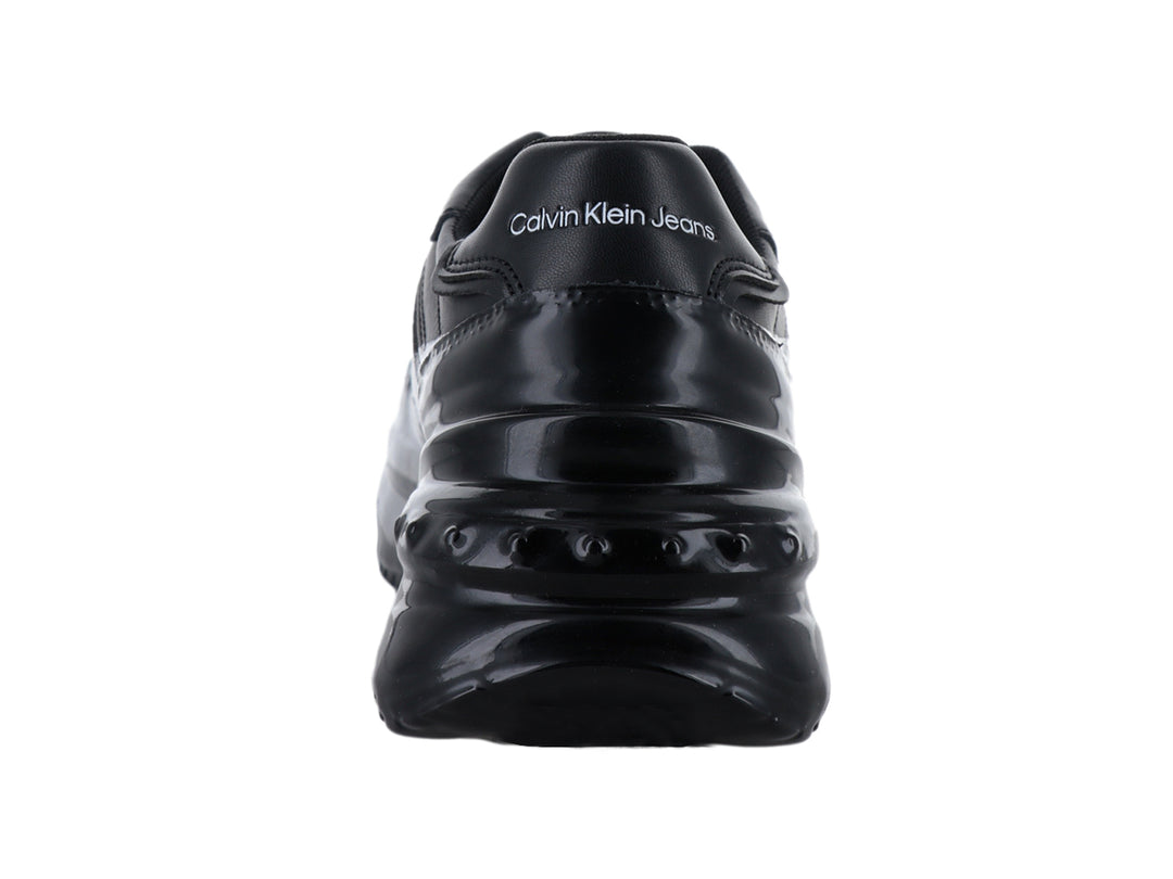 Tenis deportivos Calvin Klein en color negro brillante con suela de plataforma gruesa.