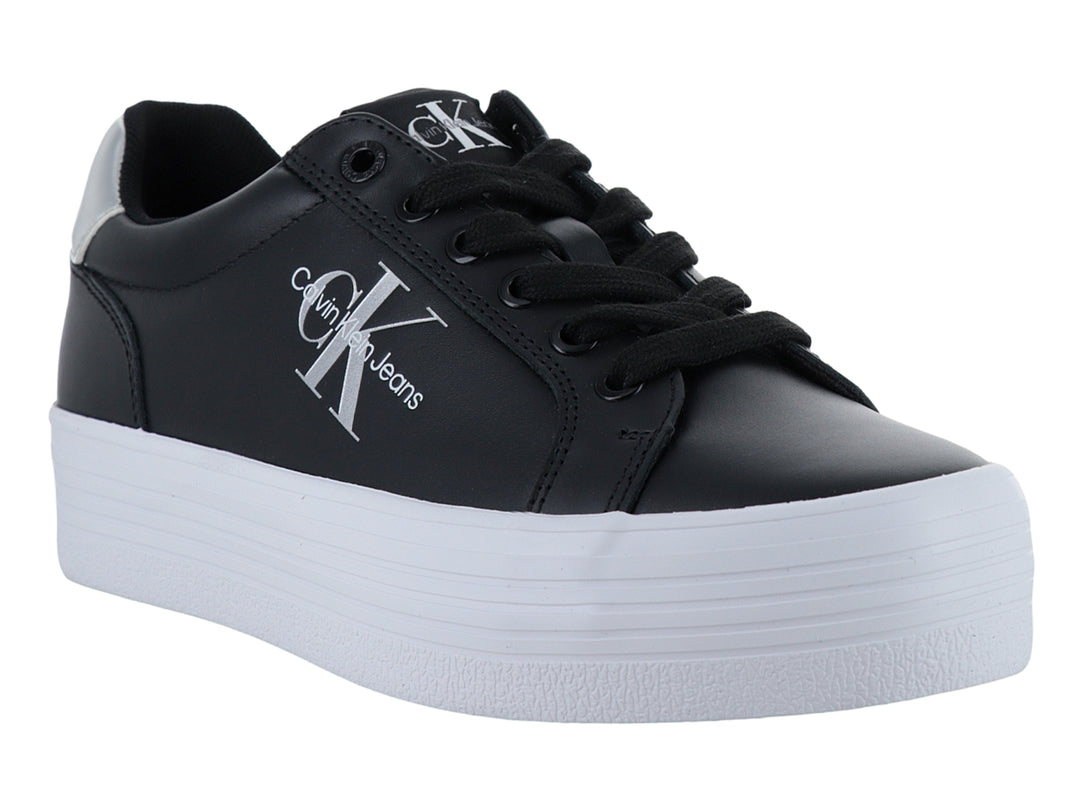 Tenis negros de plataforma Calvin Klein con suela blanca gruesa y detalles plateados.