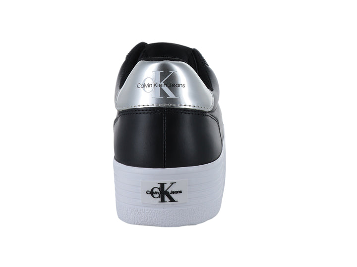 Tenis negros de plataforma Calvin Klein con suela blanca gruesa y detalles plateados.