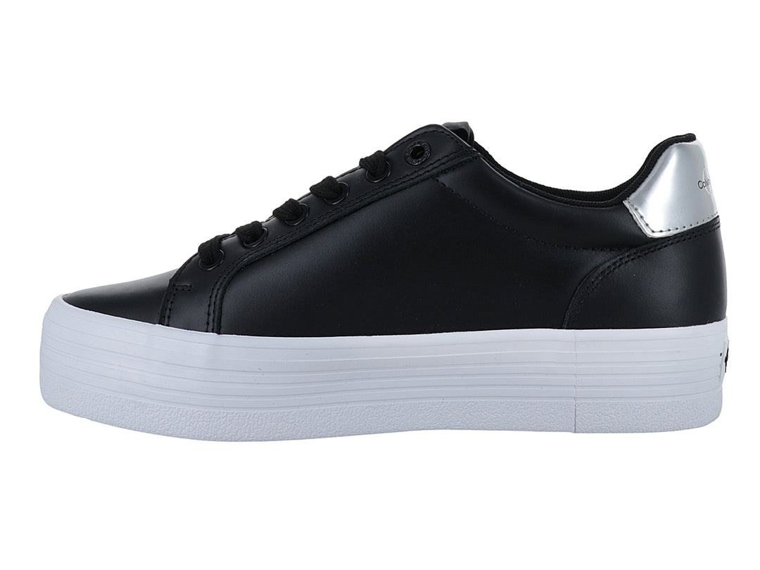 Tenis negros de plataforma Calvin Klein con suela blanca gruesa y detalles plateados.