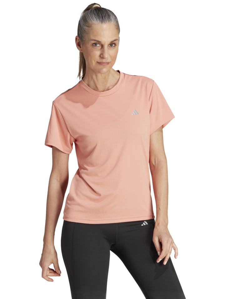 Camiseta deportiva Adidas de color coral para mujer, con cuello redondo y manga corta.