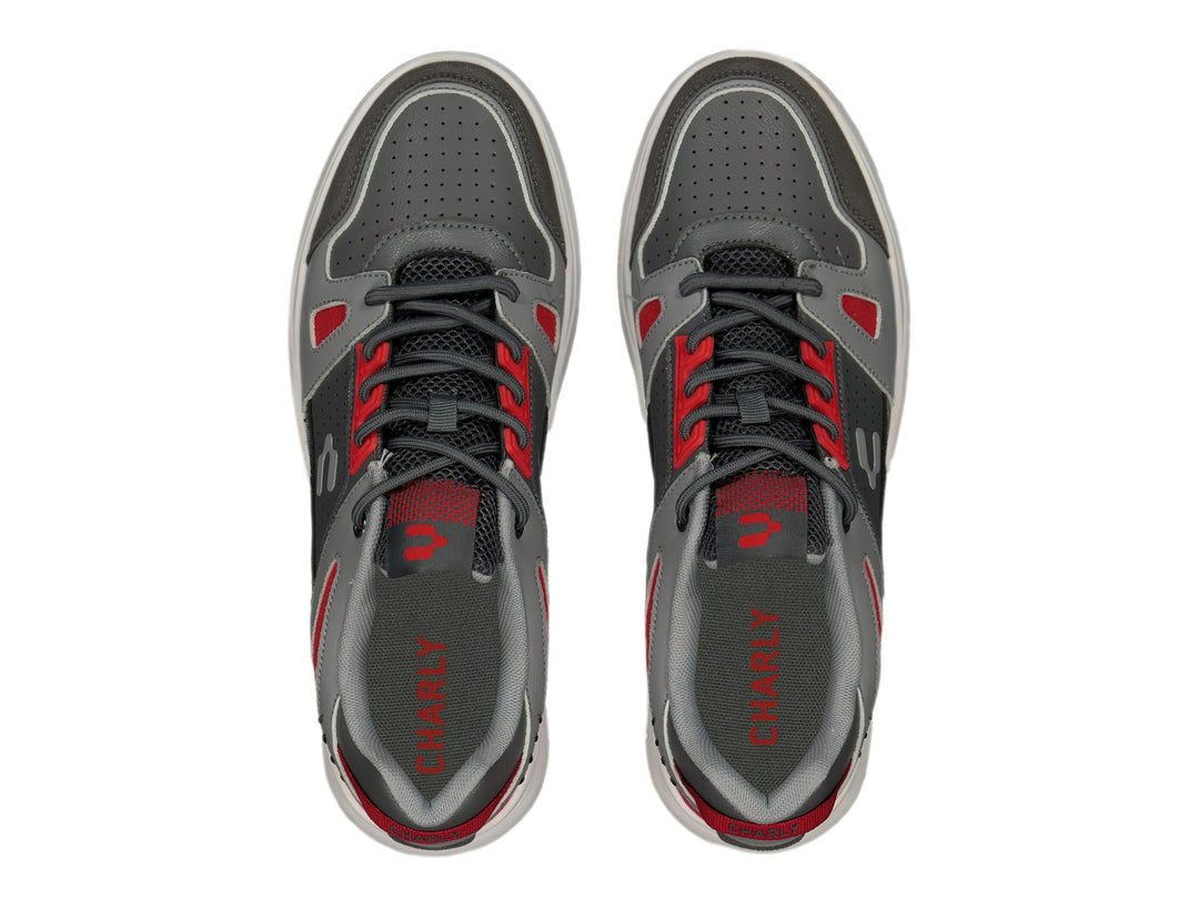 Tenis deportivos Charly color gris Oxford con detalles en rojo y suela blanca.