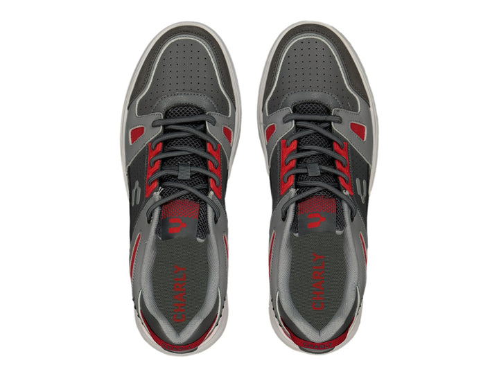 Tenis deportivos Charly color gris Oxford con detalles en rojo y suela blanca.