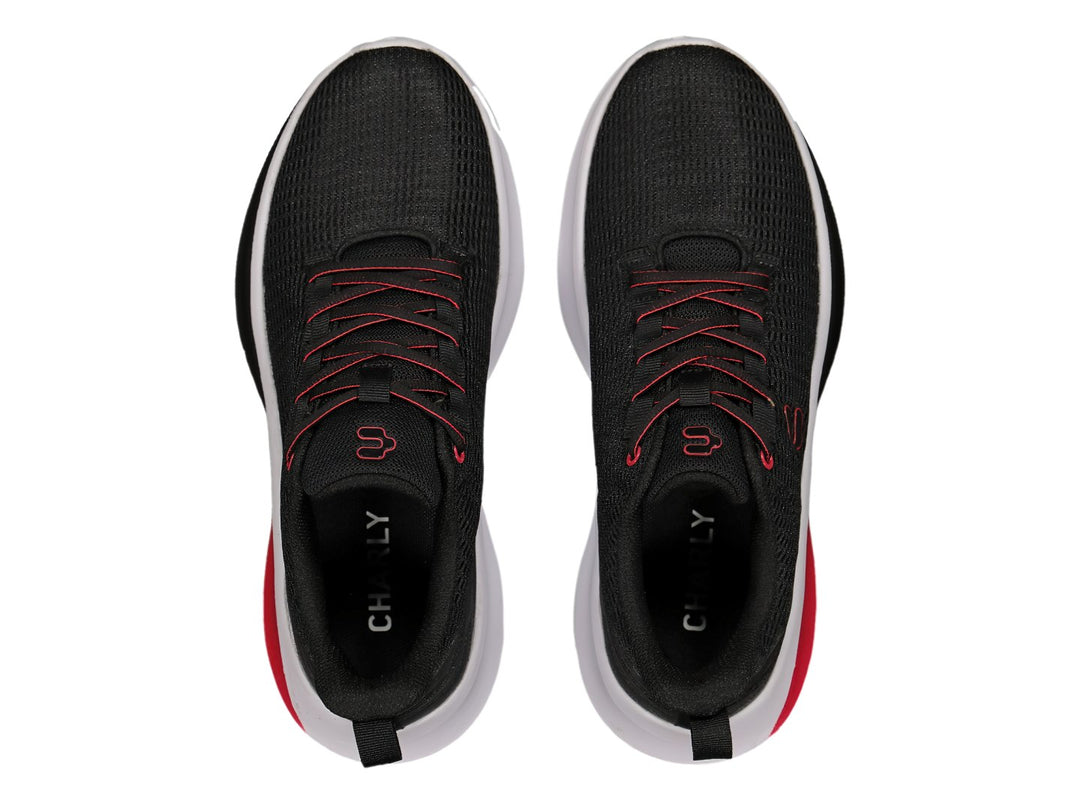 Par de tenis deportivos Charly en color negro con detalles en rojo y suela blanca.