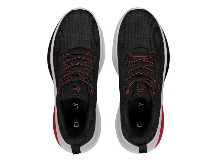 Par de tenis deportivos Charly en color negro con detalles en rojo y suela blanca.