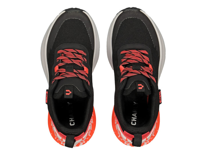 Par de tenis deportivos Charly color negro con detalles y agujetas en naranja y suela blanca.
