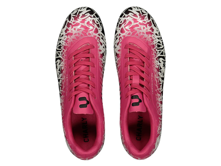 Par de zapatos de fútbol Charly en color rosa con estampado blanco y negro en la parte frontal y suela negra.