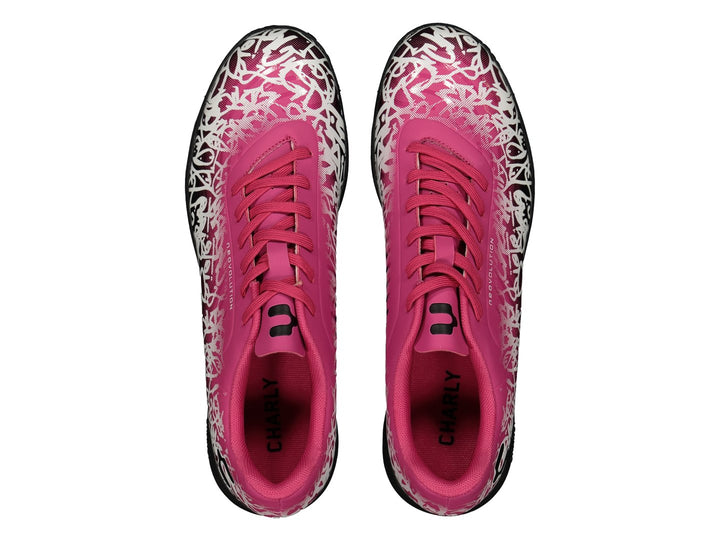 Par de zapatos de fútbol Charly en color rosa con patrones blancos y suela negra.
