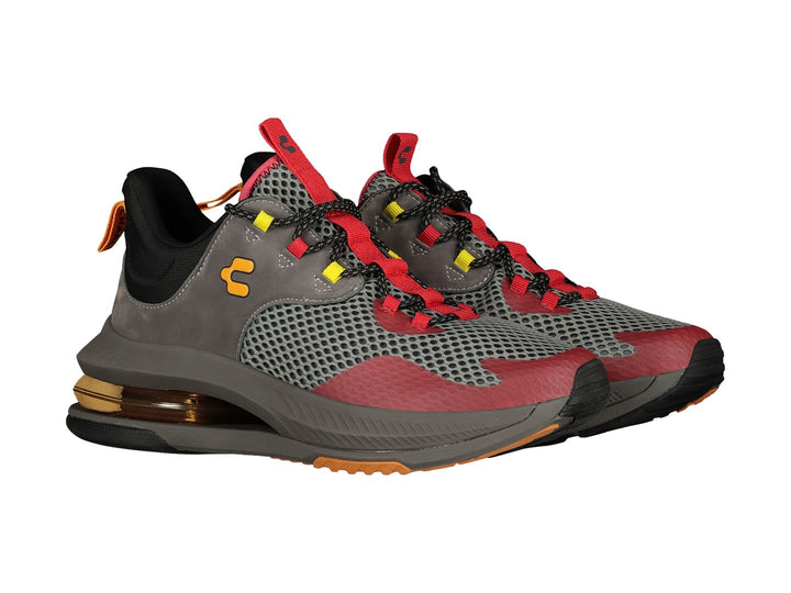 Tenis deportivos Charly color gris y rojo con detalles amarillos y suela amortiguada.