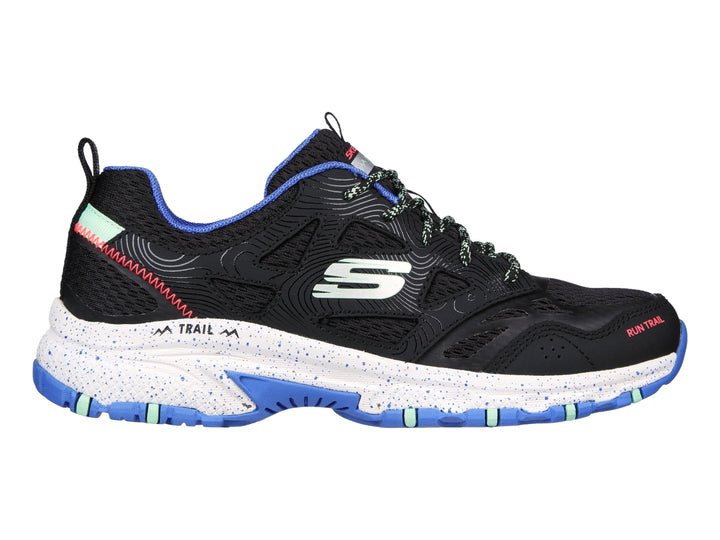 Tenis Skechers para trail running en color negro con detalles en azul y verde menta y suela blanca.