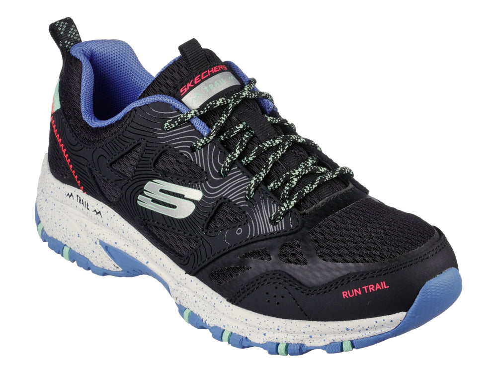 Tenis Skechers para trail running en color negro con detalles en azul y verde menta y suela blanca.